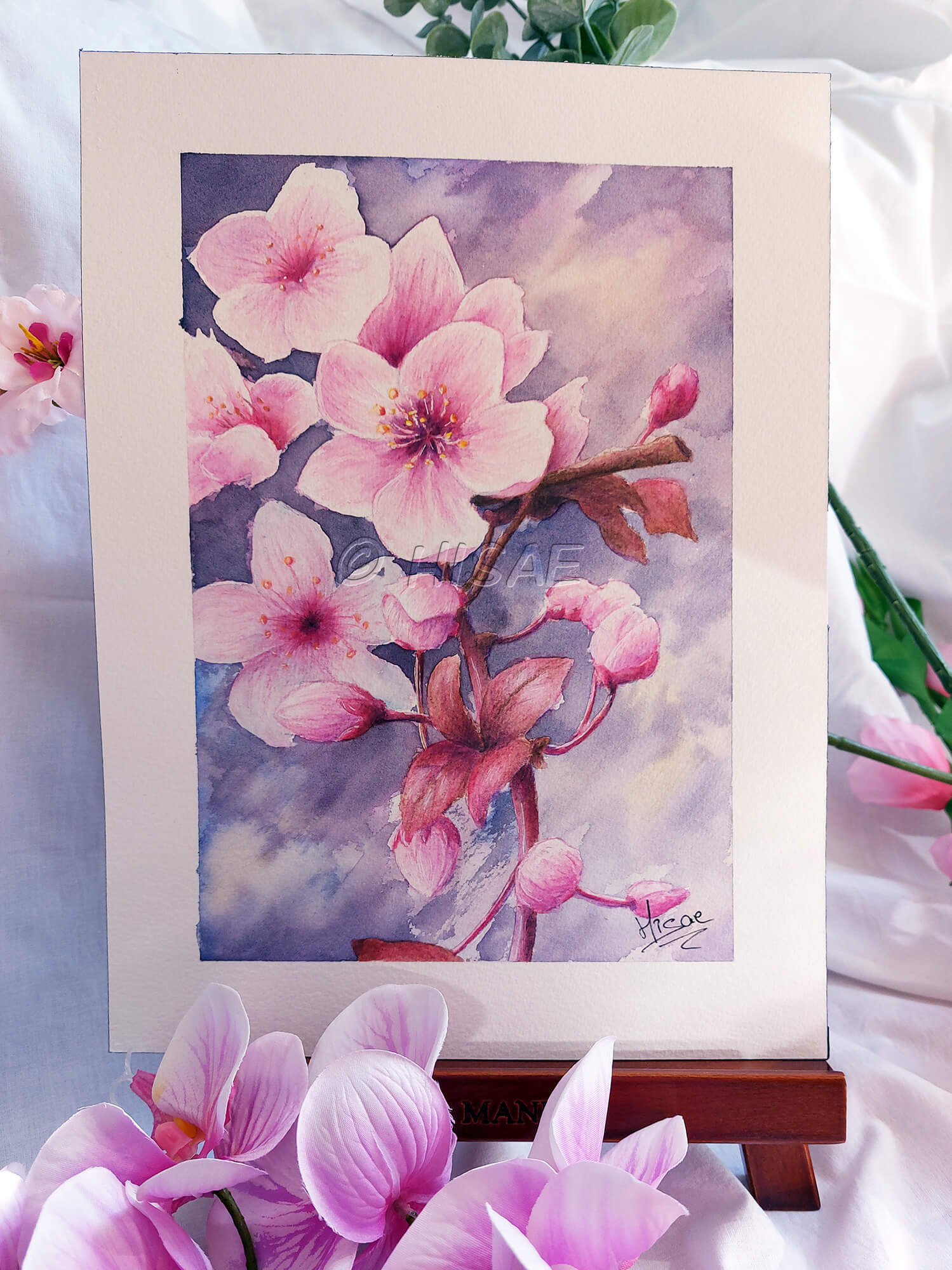 Dessin original à l'aquarelle représentant une branche de cerisier japonais et ses fleurs et présenté sur un chevalet @Hisae illustrations